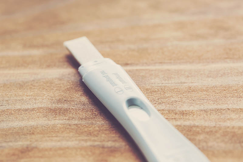 Pregnancy test kit on a wood desk