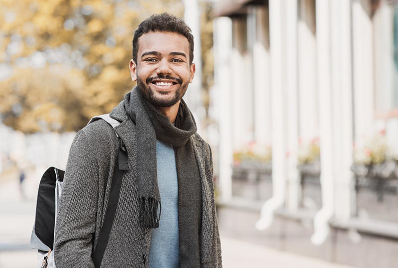 Handsome joyful man autumn portrait. Smiling men student wearing
